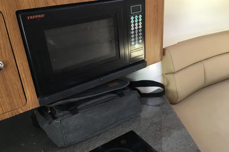 Slide: The Image of Tappan microwave in Everglades 320EX boat interior, 2013 model, with beige seating and countertop. - 48