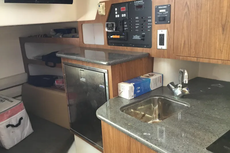 Slide: The Image of Interior of 2013 Everglades 320EX boat featuring kitchenette with sink and control panel. - 49