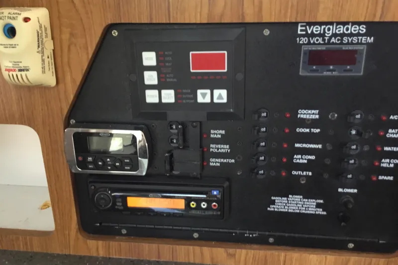 Slide: The Image of Control panel of a 2013 Everglades 320EX boat, featuring various switches and displays. - 51