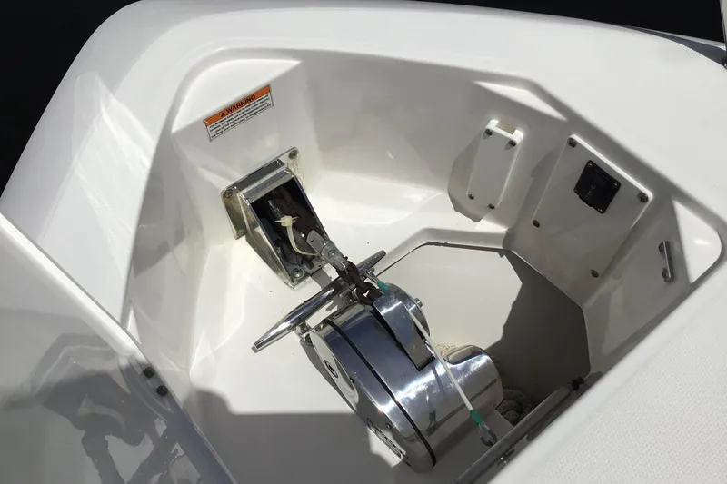 Slide: The Image of Anchor compartment of 2013 Everglades 320EX boat, featuring a winch and storage area. - 17