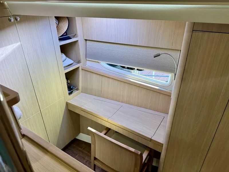 Slide: The Image of 2022 Aquila 44 yacht interior with wooden desk, chair, and shelves. - 16