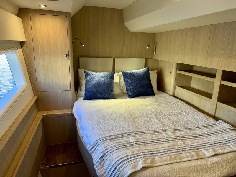 Slide: The Image of Luxurious bedroom interior of 2022 Aquila 44 yacht with modern wood finish and cozy bedding. - 18