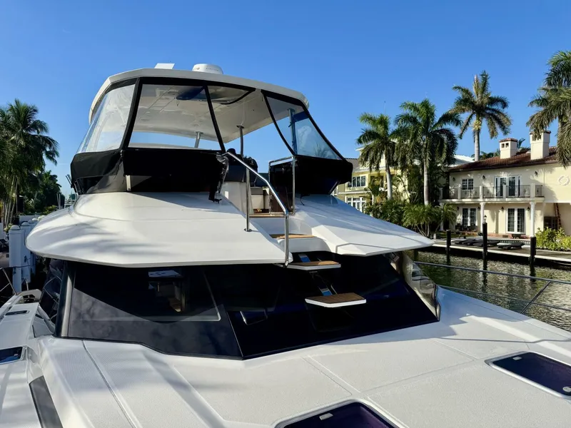 Slide: The Image of Aquila 44 yacht, 2022 model, docked near waterfront homes with palm trees. - 20