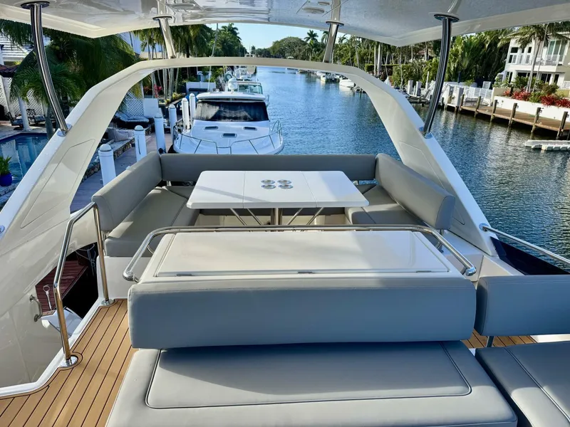 Slide: The Image of Aquila 44 yacht deck with seating and table, docked in a scenic canal, 2022 model. - 25