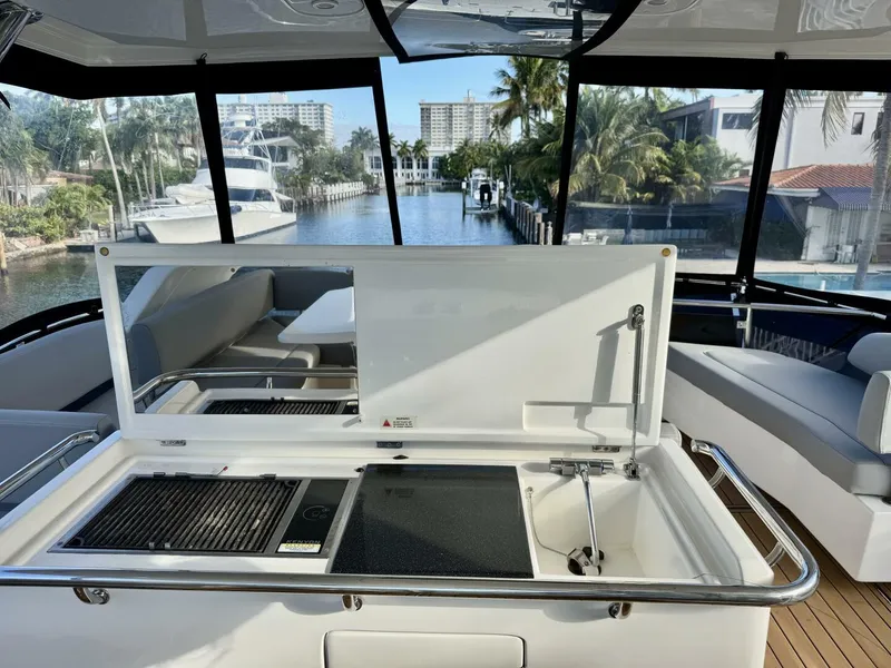 Slide: The Image of Luxury Aquila 44 yacht interior with kitchenette, overlooking marina and palm trees, 2022 model. - 26