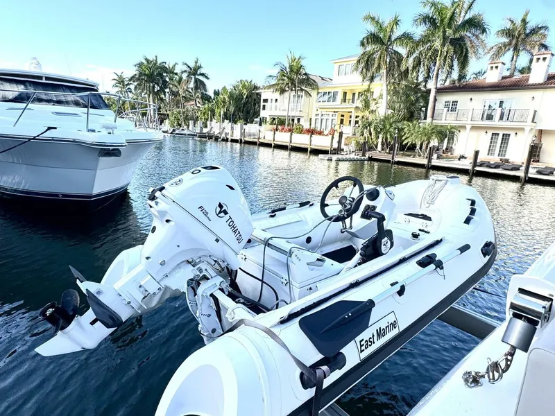 Slide: The Image of Aquila 44 yacht docked by waterfront homes, featuring a small motorboat. - 27