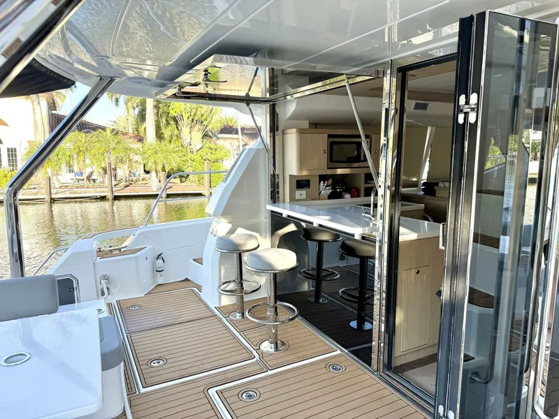 Slide: The Image of Aquila 44 yacht interior, 2022 model, featuring modern kitchen and seating area by the water. - 4
