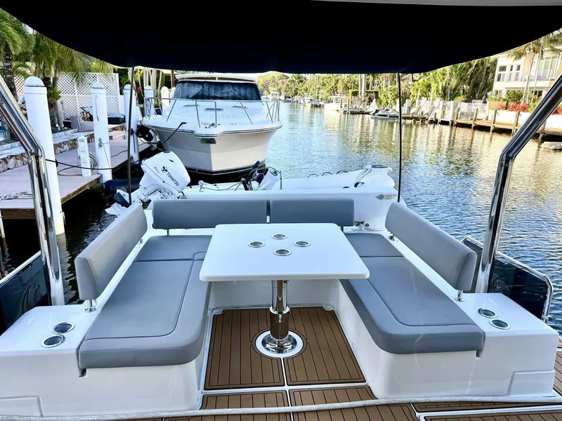 Slide: The Image of Aquila 44 yacht interior with seating and table, docked by a serene waterfront. - 5