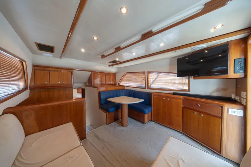 Slide: The Image of Interior of 2003 Bertram 390 Convertible yacht with wood cabinetry and seating area. - 24