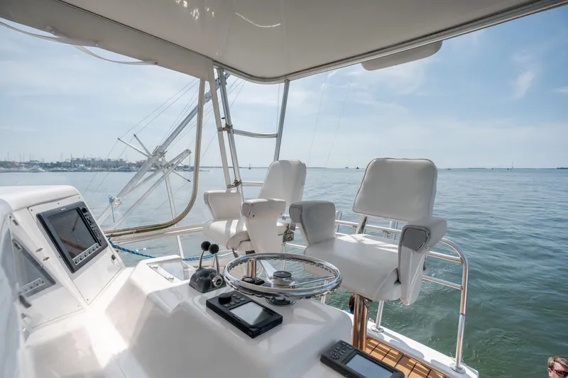 Slide: The Image of Helm of 2003 Bertram 390 Convertible yacht with ocean view and navigation equipment. - 19