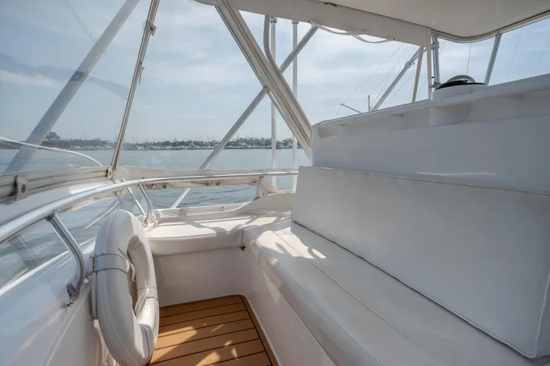 Slide: The Image of Interior view of 2003 Bertram 390 Convertible yacht, featuring white seating and ocean backdrop. - 17