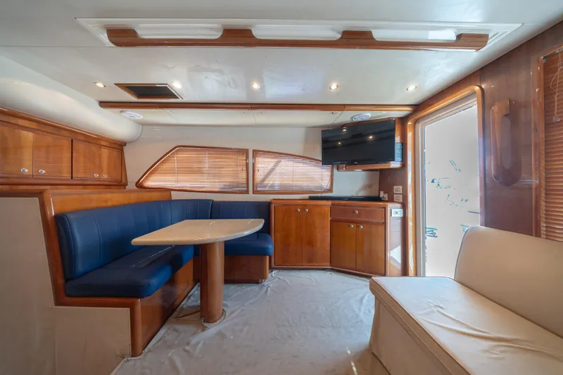 Slide: The Image of Interior of 2003 Bertram 390 Convertible yacht with dining area and TV. - 25