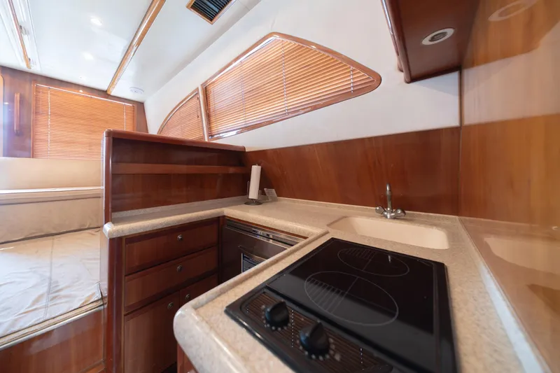 Slide: The Image of 2003 Bertram 390 Convertible yacht interior with modern kitchen and wooden cabinetry. - 28