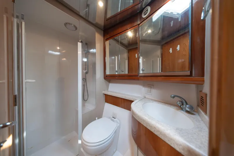 Slide: The Image of Luxurious bathroom in a 2003 Bertram 390 Convertible yacht, featuring modern fixtures and wood accents. - 37