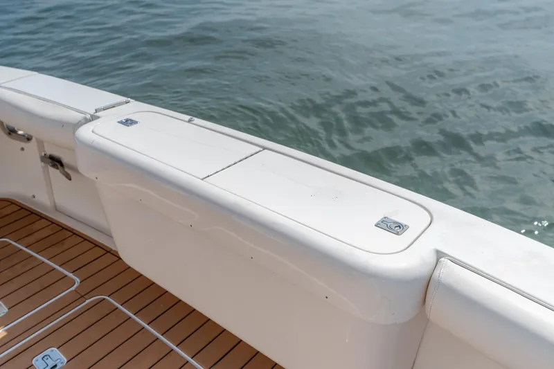 Slide: The Image of 2003 Bertram 390 Convertible boat deck with teak flooring and white storage compartments. - 55