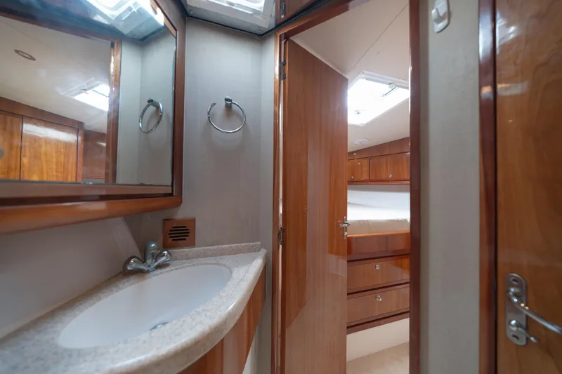 Slide: The Image of Bathroom interior of 2003 Bertram 390 Convertible yacht, featuring sink and wooden cabinetry. - 30