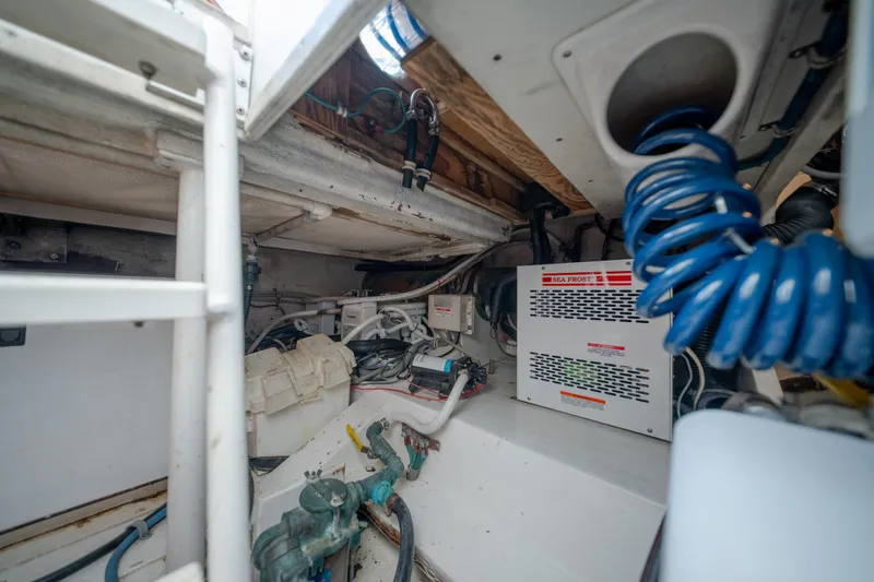 Slide: The Image of Engine room of a 2003 Bertram 390 Convertible boat, featuring mechanical equipment and wiring. - 47