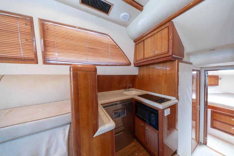 Slide: The Image of Interior of 2003 Bertram 390 Convertible yacht with wooden cabinetry and modern kitchen amenities. - 27