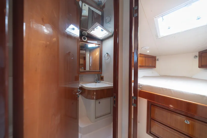Slide: The Image of Interior of 2003 Bertram 390 Convertible yacht with wood cabinetry and cozy sleeping area. - 31