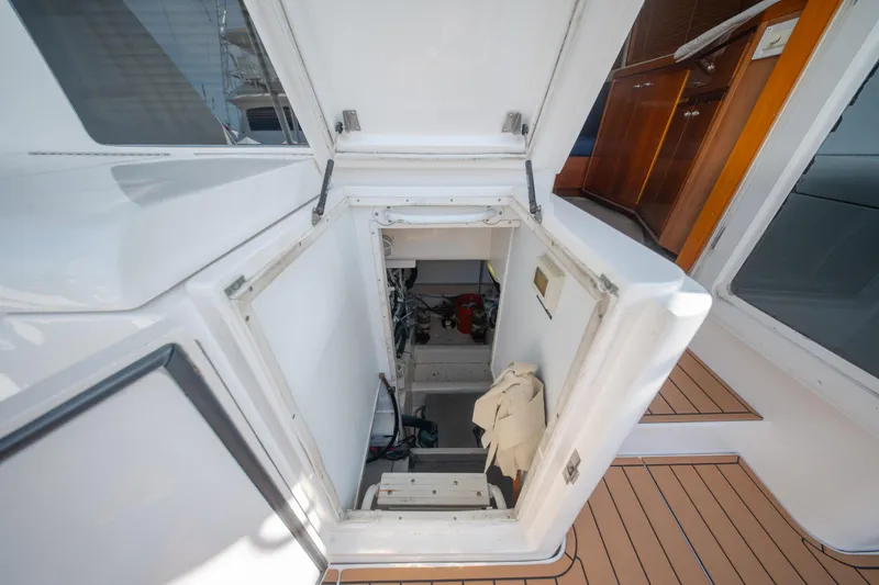 Slide: The Image of Engine room access on a 2003 Bertram 390 Convertible yacht, featuring teak flooring. - 38