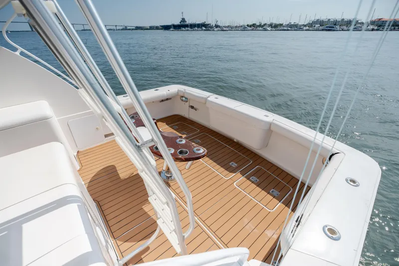 Slide: The Image of 2003 Bertram 390 Convertible yacht deck with teak flooring, overlooking marina waters. - 53