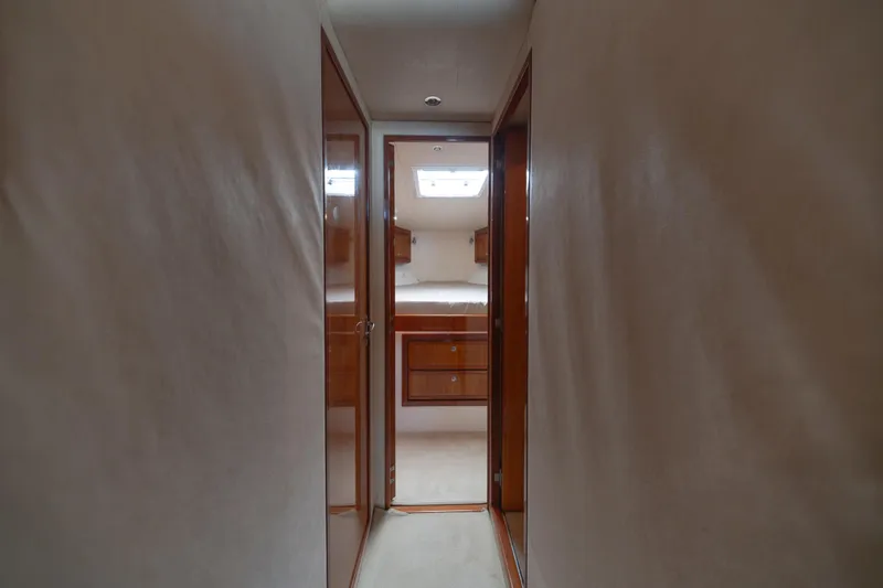 Slide: The Image of Hallway view inside 2003 Bertram 390 Convertible yacht, featuring wooden cabinetry and soft lighting. - 29