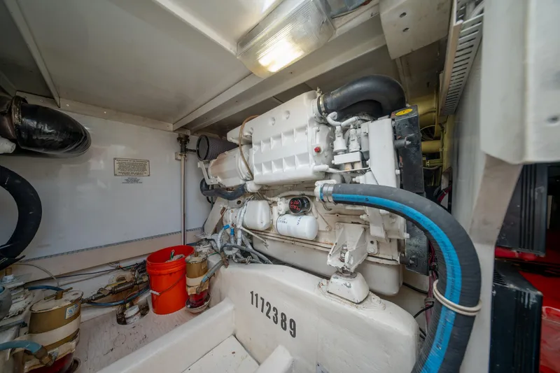 Slide: The Image of Engine room of a 2003 Bertram 390 Convertible boat, featuring mechanical components and hoses. - 40