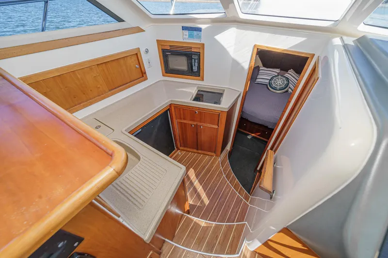 Slide: The Image of 2006 Riviera 33 Open Flybridge interior with kitchenette and cozy cabin. - 10