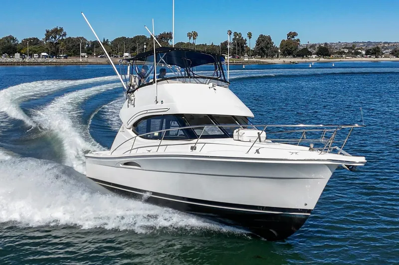 Slide: The Image of 2006 Riviera 33 Flybridge cruising on a sunny day in open water. - 12