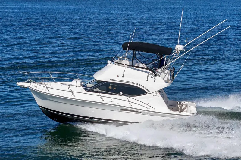 Slide: The Image of 2006 Riviera 33 Flybridge cruising on open water, showcasing sleek design and performance. - 13