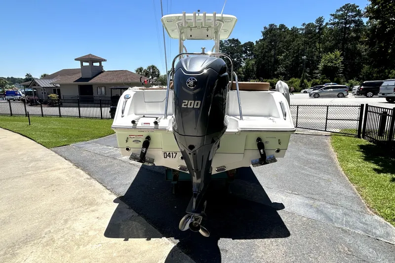 Slide: The Image of 2024 Sea Hunt Ultra 234 boat with 200 horsepower engine, parked outdoors. - 2