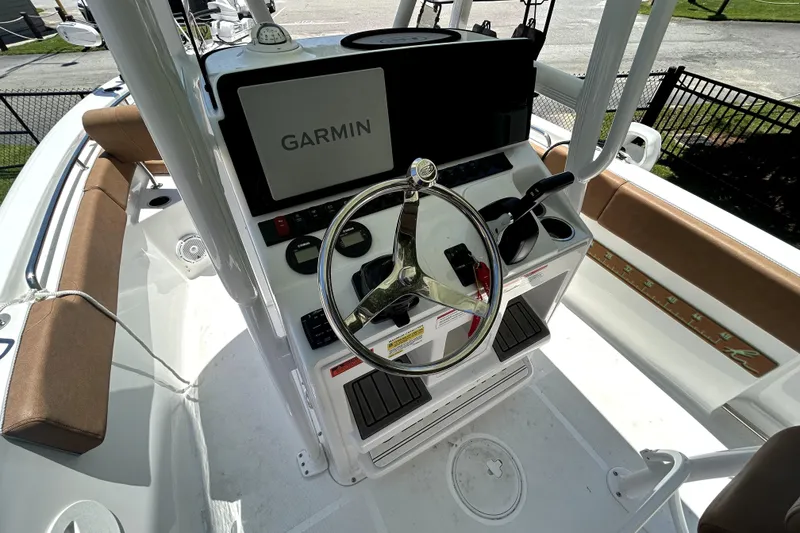 Slide: The Image of 2024 Sea Hunt Ultra 234 boat helm with Garmin navigation system and steering wheel. - 7