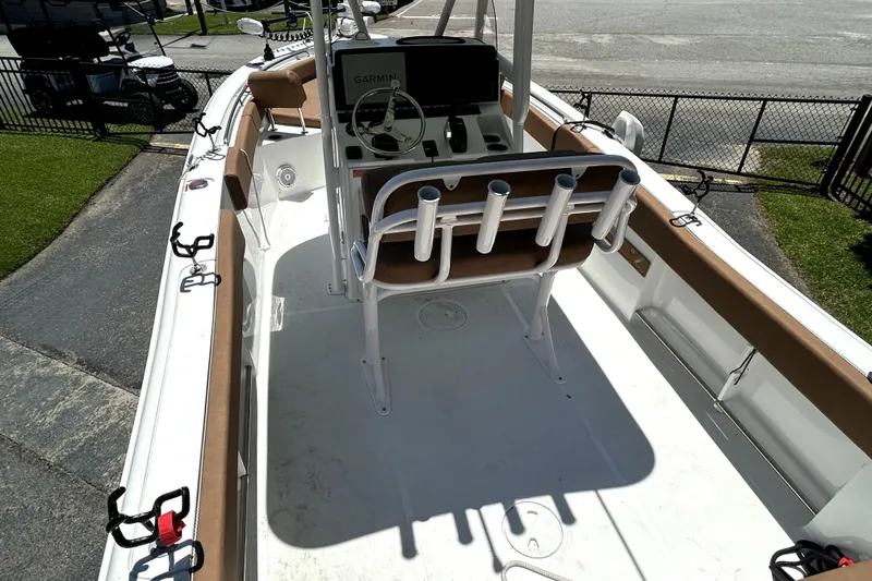 Slide: The Image of 2024 Sea Hunt Ultra 234 boat interior with helm, seating, and rod holders. - 8