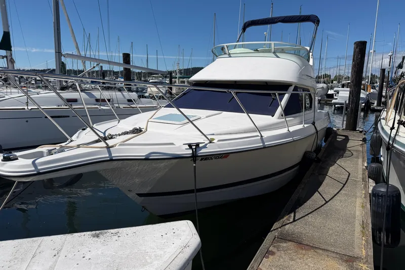 The Image of 2005 Bayliner 288 Classic boat docked at a marina under clear blue skies. - 1