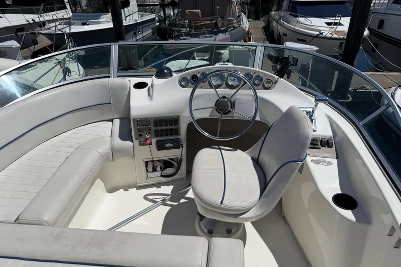 Slide: The Image of 2005 Bayliner 288 Classic boat cockpit with steering wheel and seating in marina. - 12