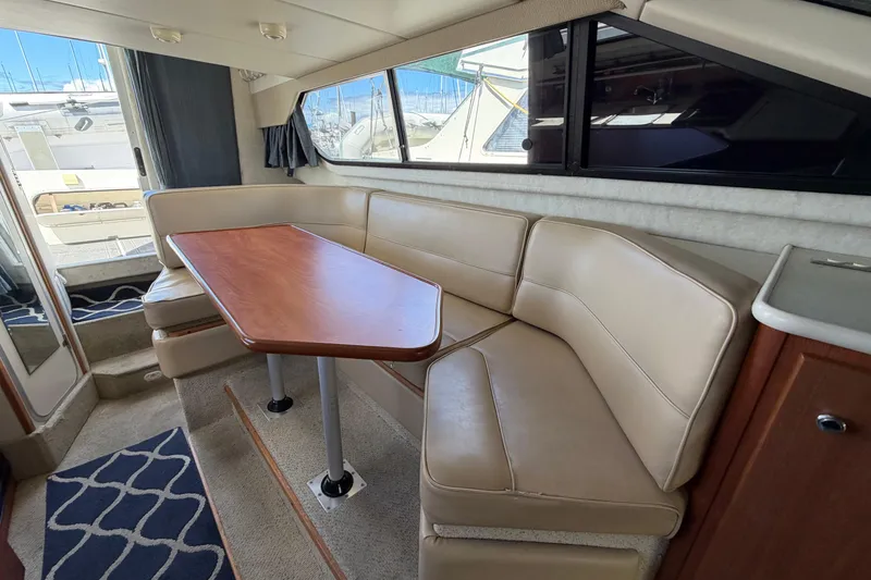 Slide: The Image of Interior of 2005 Bayliner 288 Classic boat with beige seating and wooden table. - 3