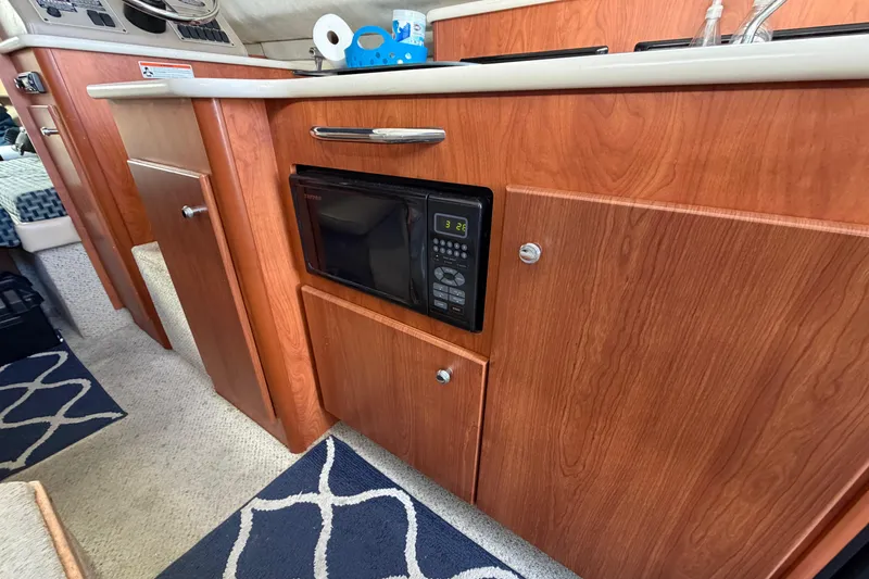 Slide: The Image of 2005 Bayliner 288 Classic boat interior with wooden cabinetry and built-in microwave. - 7