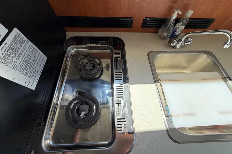 Slide: The Image of 2005 Bayliner 288 Classic kitchen with stove, sink, and countertop essentials. - 8
