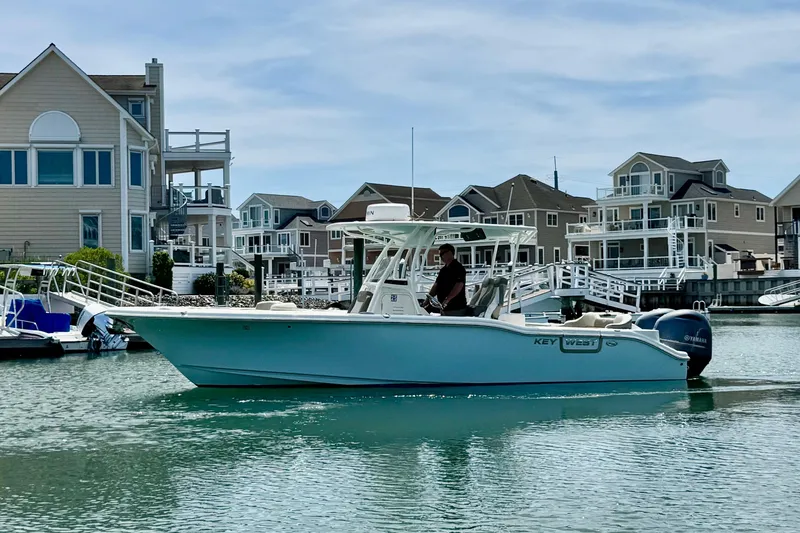 The Image of 2022 Key West 263 FS boat cruising near waterfront homes. - 1