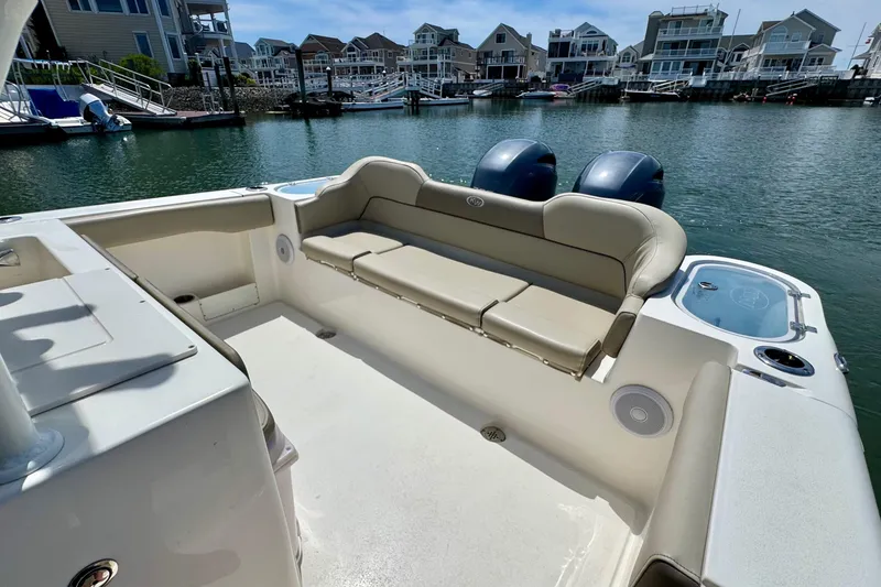 Slide: The Image of 2022 Key West 263 FS boat interior with seating, docked near waterfront homes. - 15