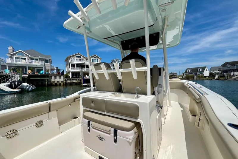Slide: The Image of 2022 Key West 263 FS boat cruising near waterfront homes under a clear blue sky. - 16