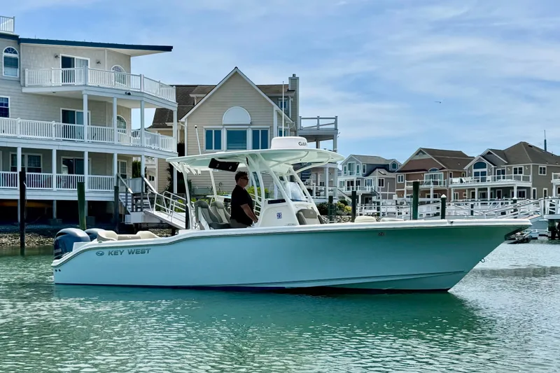 Slide: The Image of 2022 Key West 263 FS boat cruising near waterfront homes on a sunny day. - 4