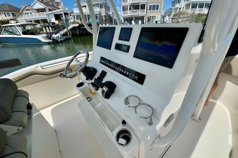 Slide: The Image of 2022 Key West 263 FS boat dashboard with navigation screens and controls. - 9