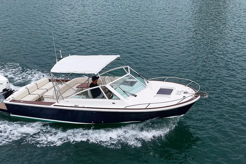 Slide: The Image of 2020 Hunt Yachts Harrier 26 cruising on open water, featuring sleek design and canopy. - 15
