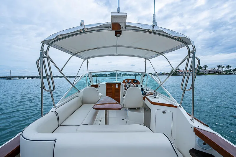 Slide: The Image of 2020 Hunt Yachts Harrier 26 interior with seating and helm, on calm water. - 16