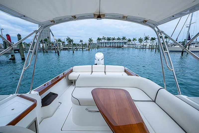 Slide: The Image of 2020 Hunt Yachts Harrier 26 with elegant seating, docked in a scenic marina. - 19