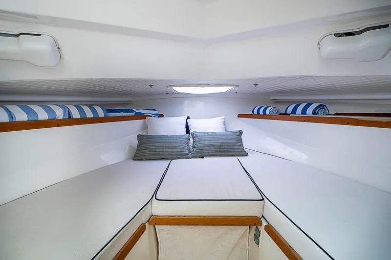 Slide: The Image of Cozy cabin interior of 2020 Hunt Yachts Harrier 26 with striped towels and cushions. - 24