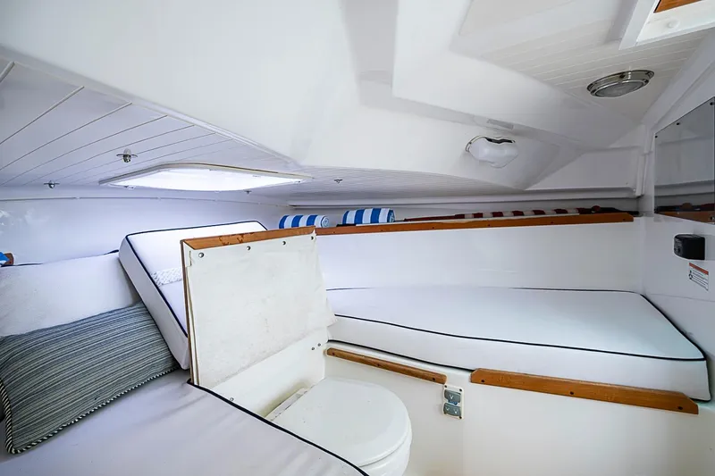 Slide: The Image of 2020 Hunt Yachts Harrier 26 cabin interior with white cushions and wooden accents. - 26