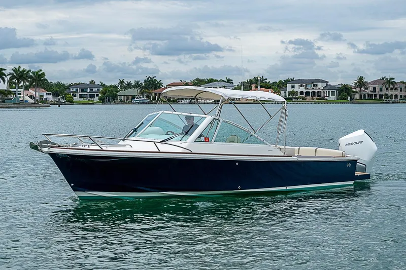 Slide: The Image of 2020 Hunt Yachts Harrier 26 boat on calm water with luxury homes in background. - 4