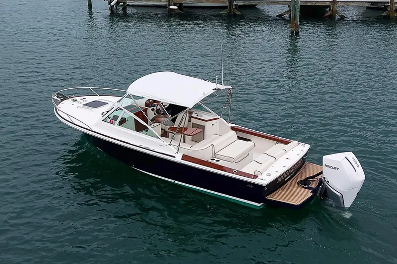Slide: The Image of 2020 Hunt Yachts Harrier 26 boat on water, featuring sleek design and Mercury outboard engine. - 6